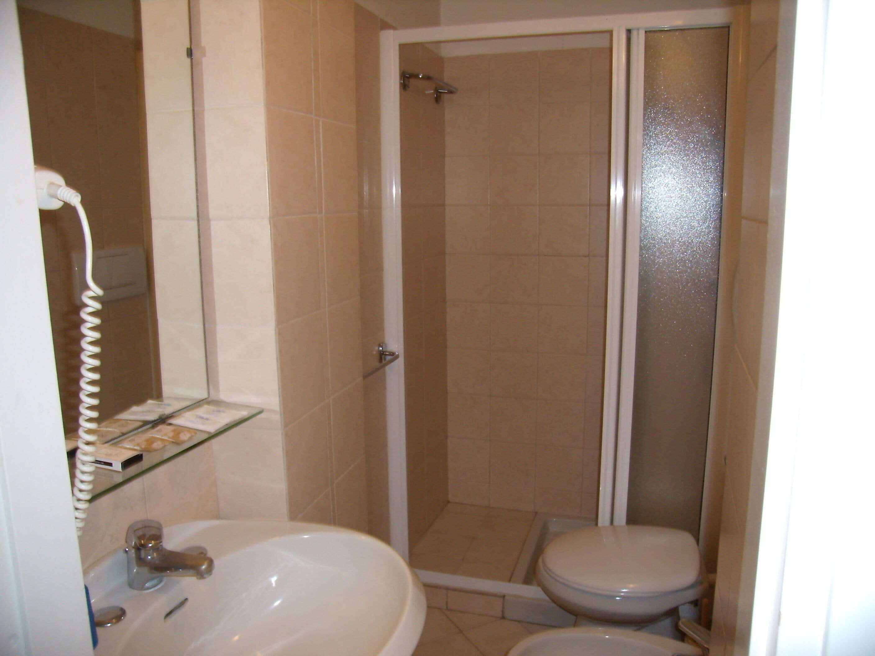 Une salle de bain avec un lavabo, des toilettes et une douche.