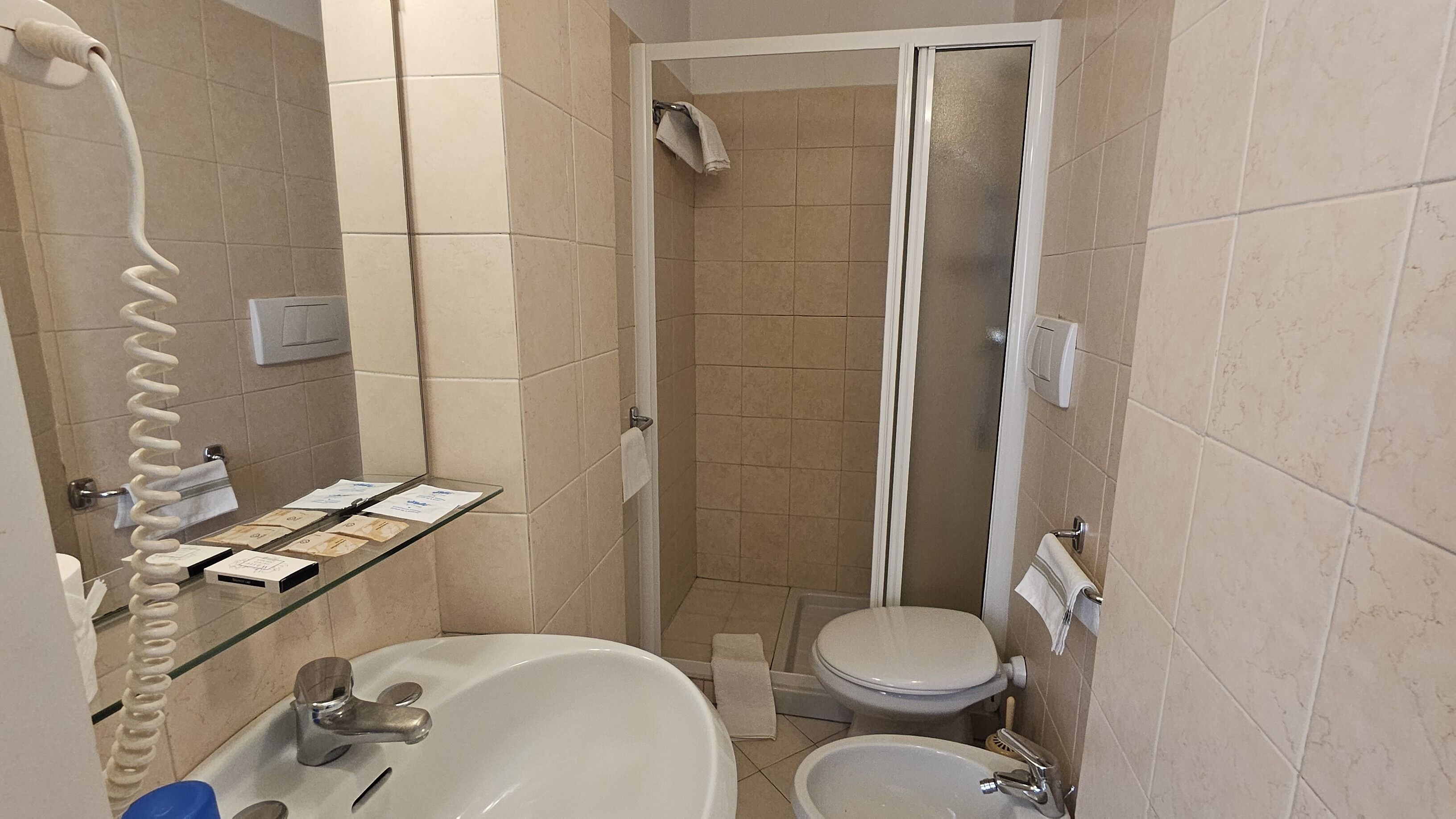 Une salle de bain de taille réduite comprenant une baignoire, des toilettes et un espace douche.