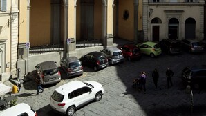 A courtyard with a historic building featuring arched doorways and a tower. - La Perla (Siena)
