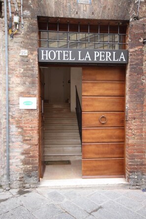 A hotel entrance with a sign reading 'HOTEL LA PERLA'. - La Perla (Siena)