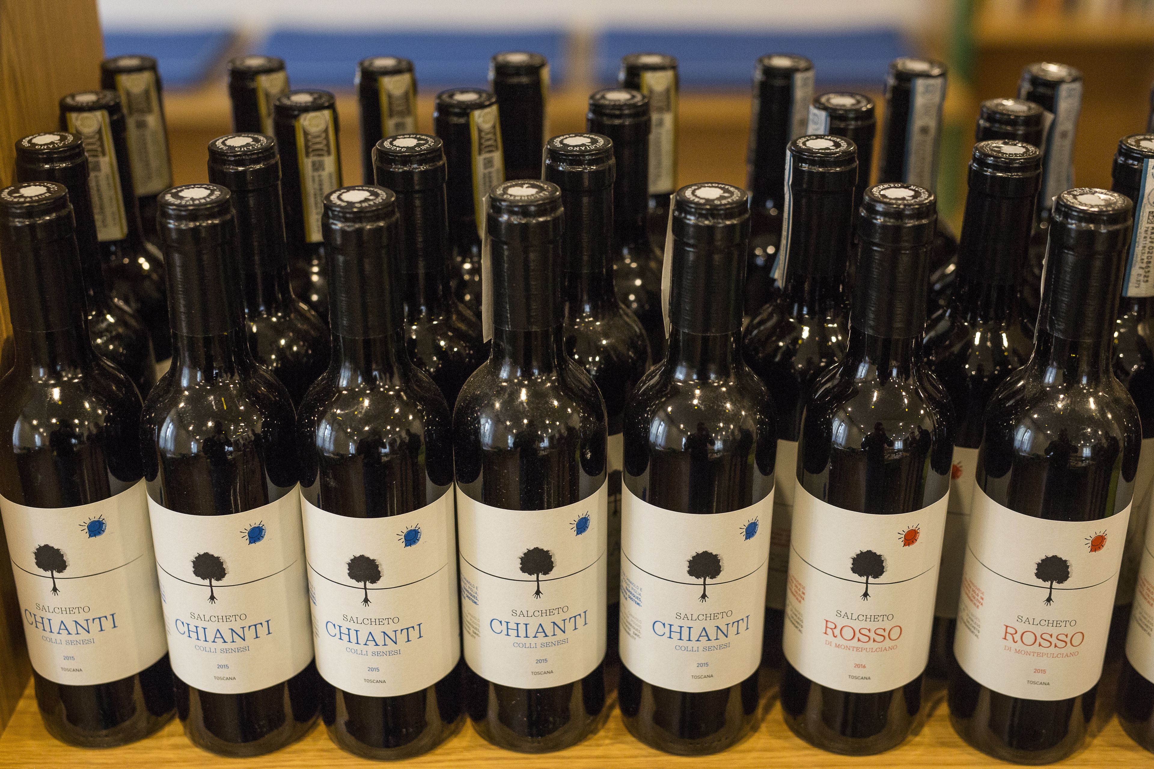 A collection of wine bottles with labels indicating they are from the Chianti and Rosso varieties, produced in 2015.