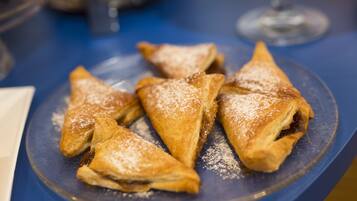 A plate of triangular pastries dusted with powdered sugar.