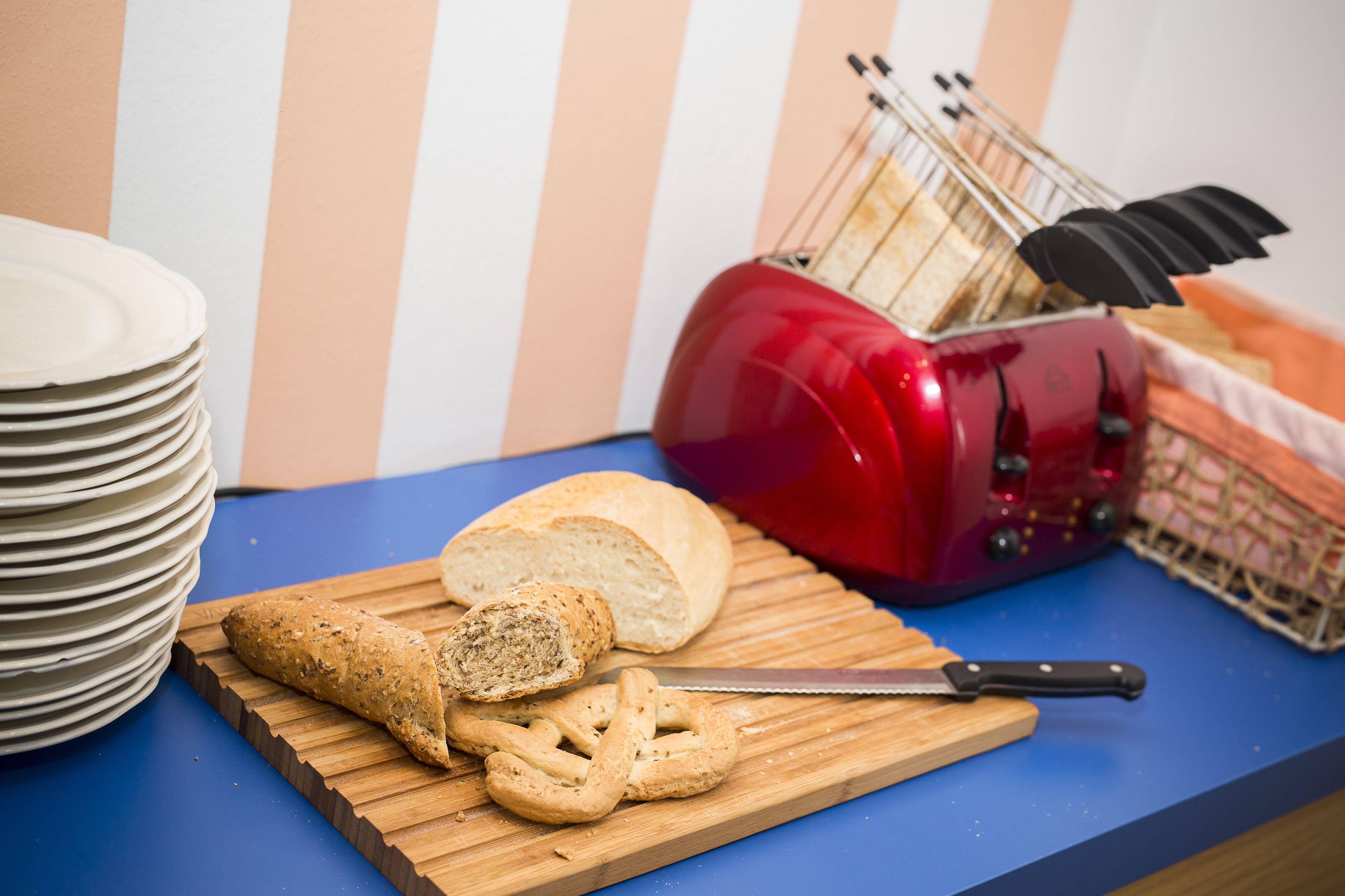A kitchen counter with a loaf of bread, a knife, and a cutting board.