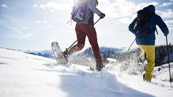 Two skiers in motion on a snowy slope with a clear sky.