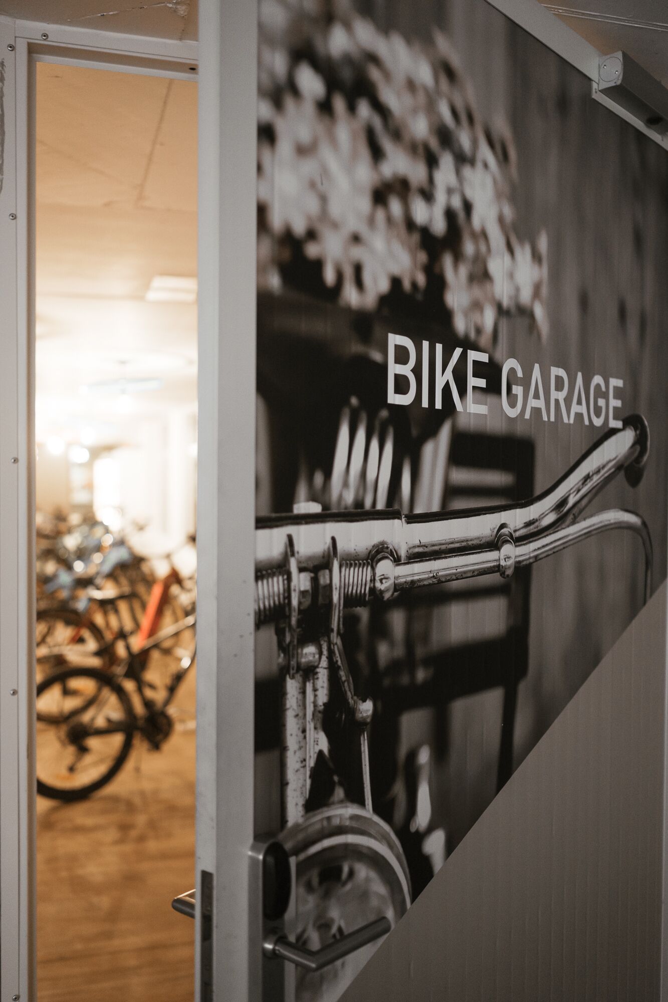 A bike garage with a bicycle rack and a door leading to a room with bicycles.