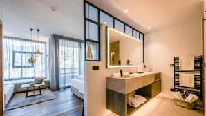 Ein modernes Badezimmer mit großem Spiegel, integriertem Waschbecken und Handtuchhalter.