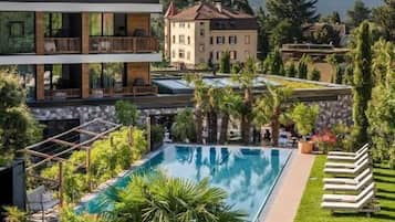 Una piscina cubierta, una piscina al aire libre, sombrillas, tumbonas