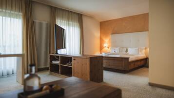A hotel room with a bed, bedside table, desk, and a lamp.
