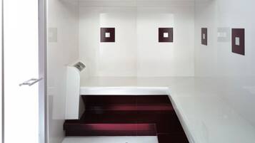 Un ascensor moderno con un diseño elegante, que presenta un interior blanco y detalles oscuros en las paredes y los peldaños.