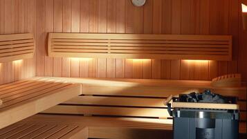 A sauna with wooden benches and a heater.