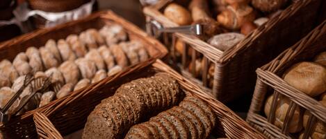 A variety of breads and pastries displayed in wicker baskets.