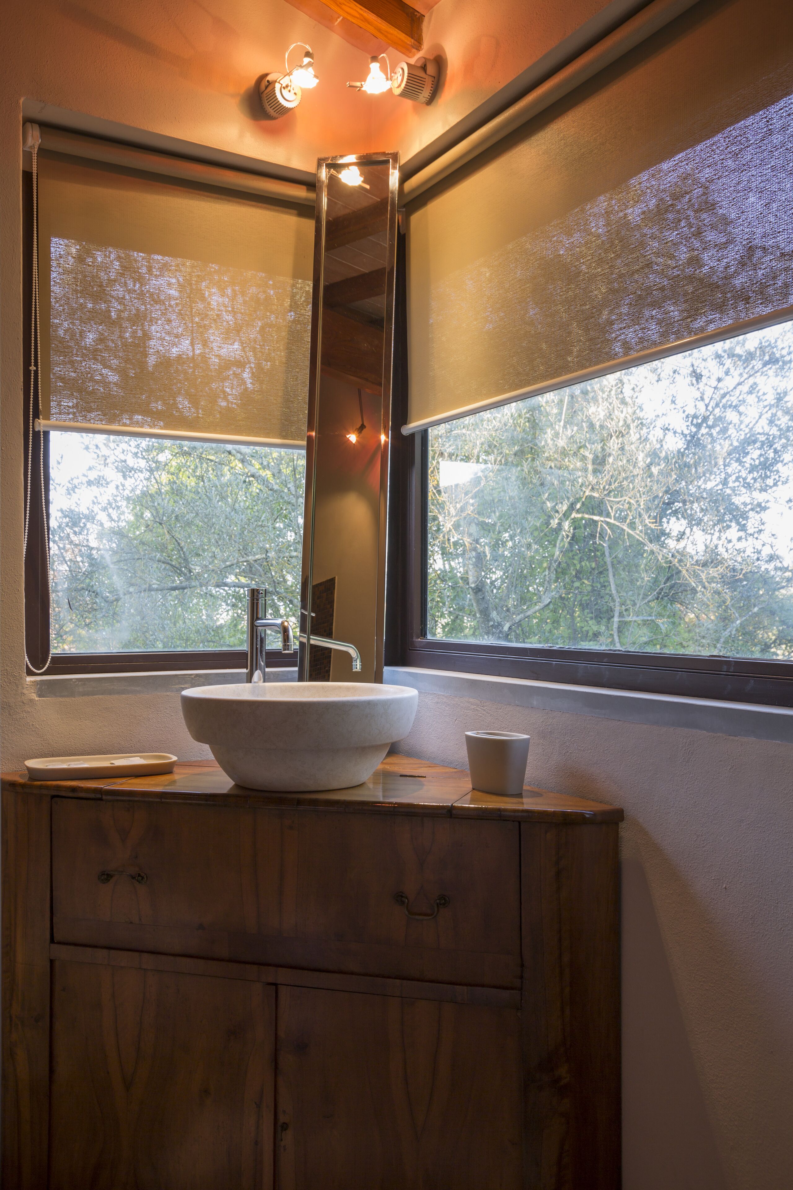 A bathroom with a wooden vanity, a white sink, and a large mirror above it.