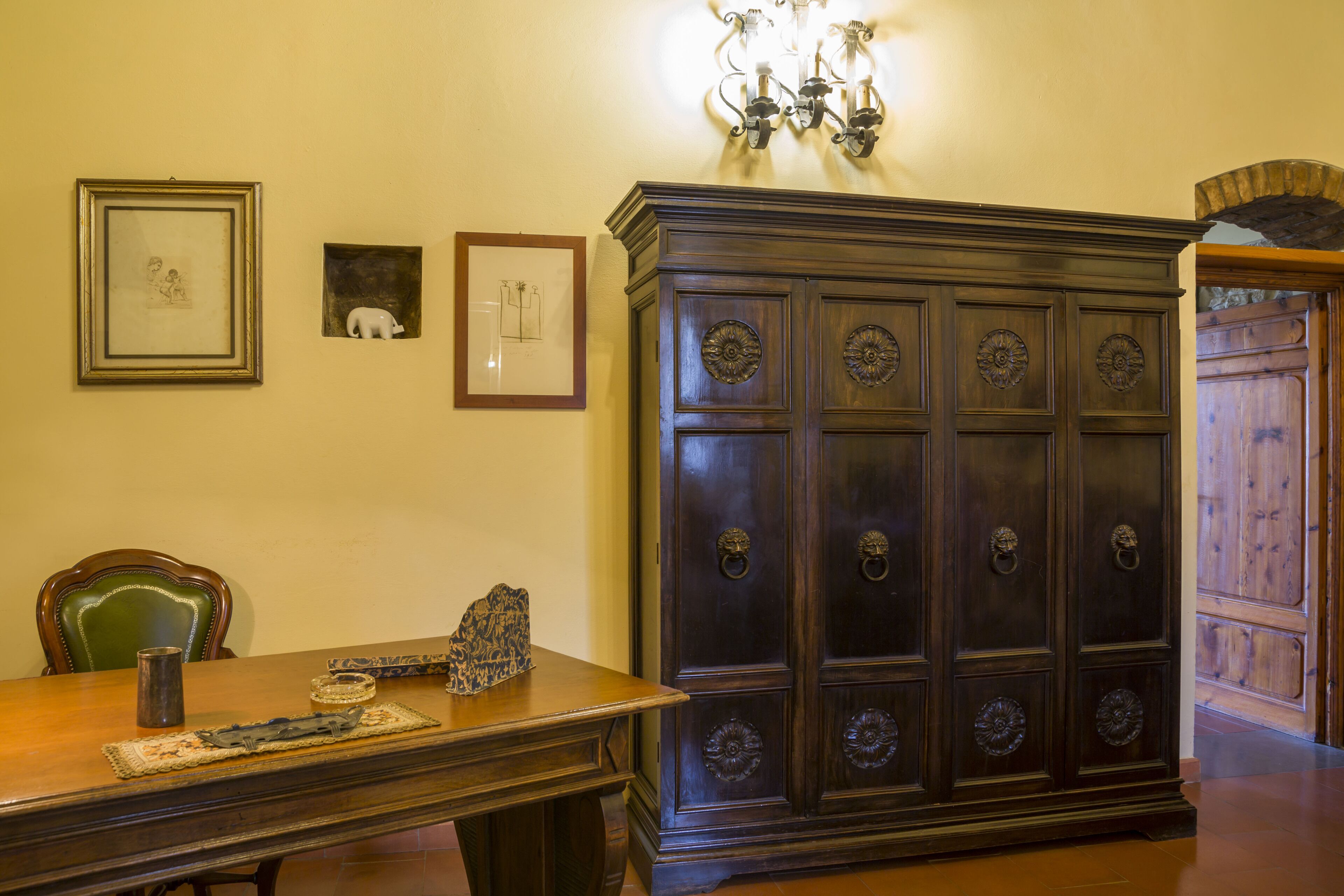 Ein Essbereich mit einem Holztisch, Stühlen und einem Schrank mit verzierten Griffen.