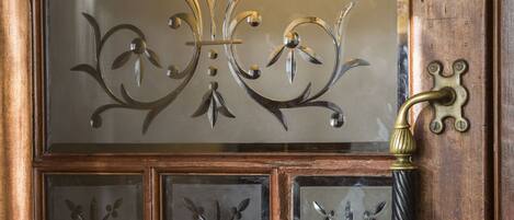 A wooden door with a glass panel featuring decorative metalwork and the text "SAINTS BAR."