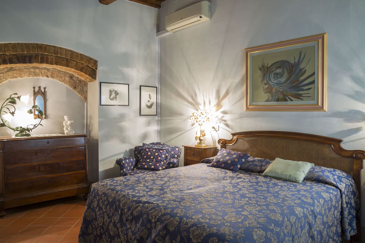 Ein Schlafzimmer mit Bett, Schminktisch und Wandklimaanlage.