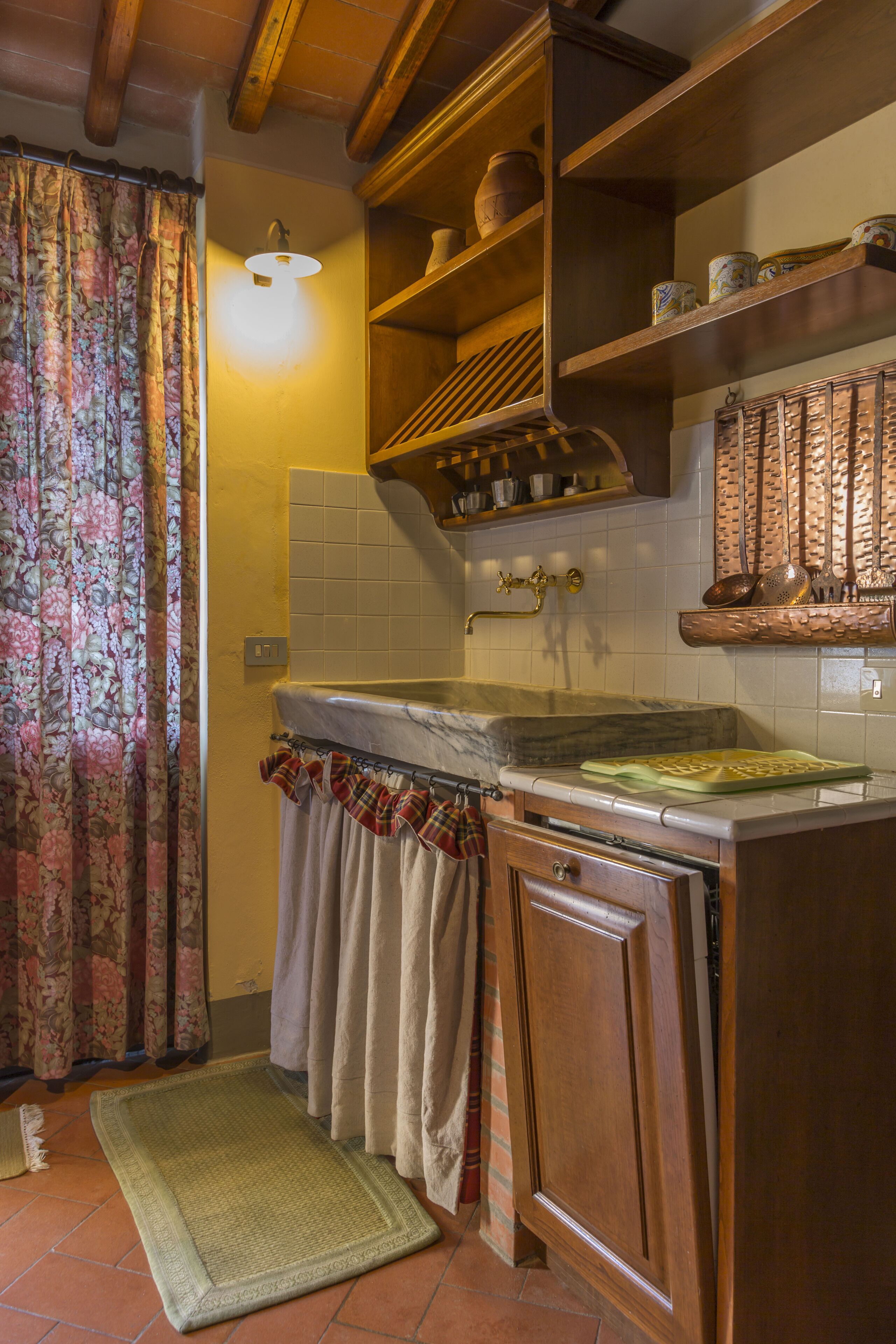 A kitchen with wooden cabinets, a marble countertop, and a tiled backsplash.