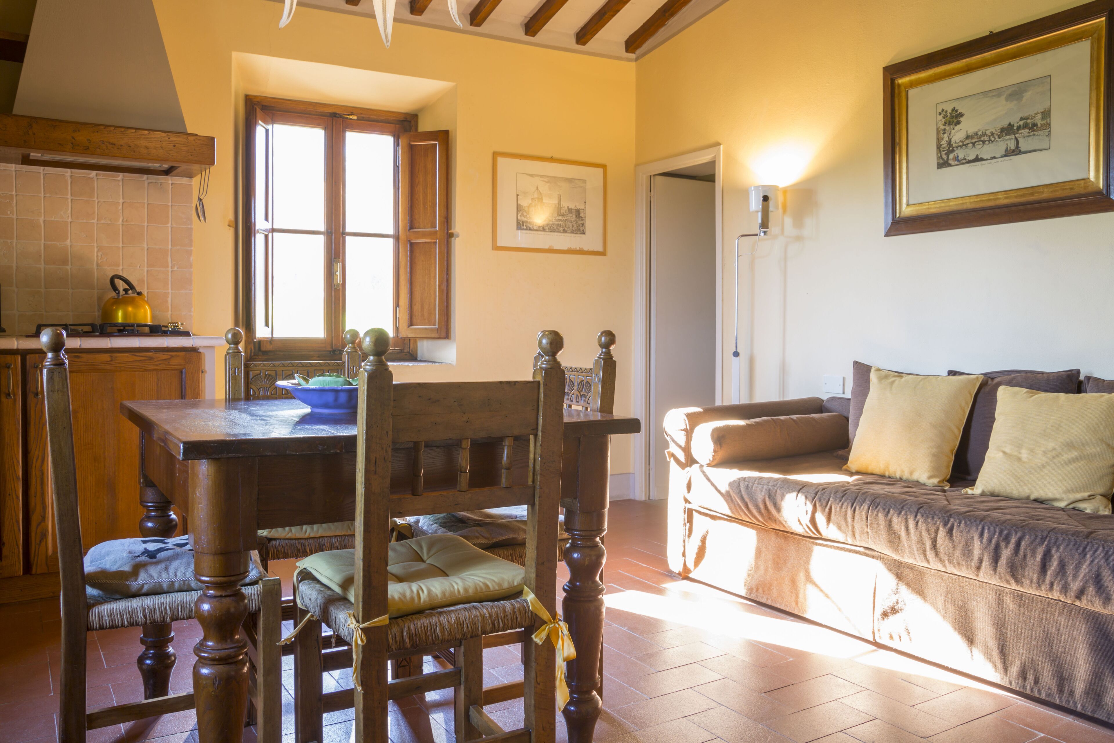 Una sala de estar acogedora con una mesa de comedor de madera, sillas y un sofá.
