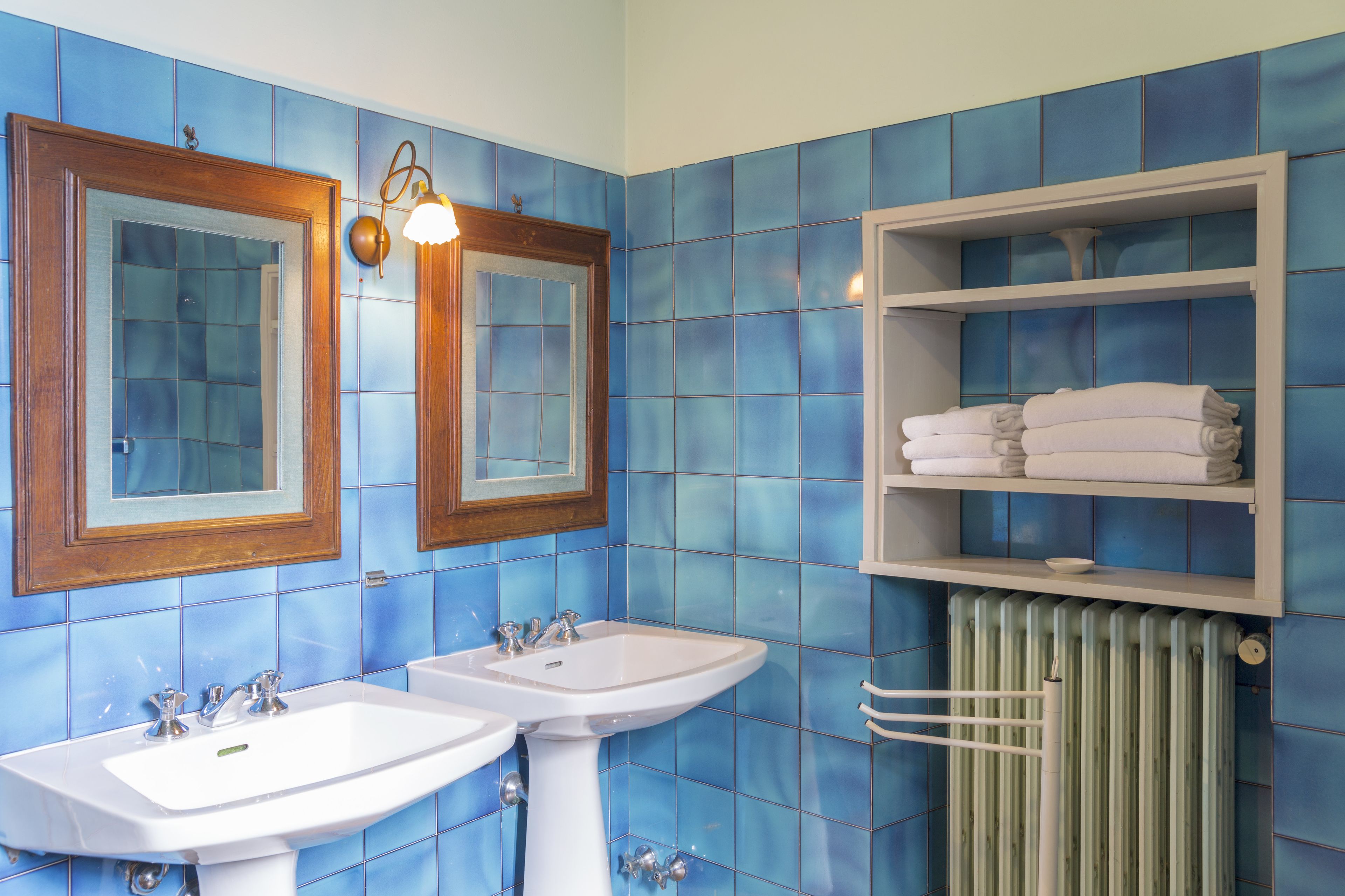Un baño con dos lavamanos, un espejo y un perchero para toallas.