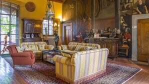 Een klassieke woonkamer met een zithoek, een salontafel en een open haard.