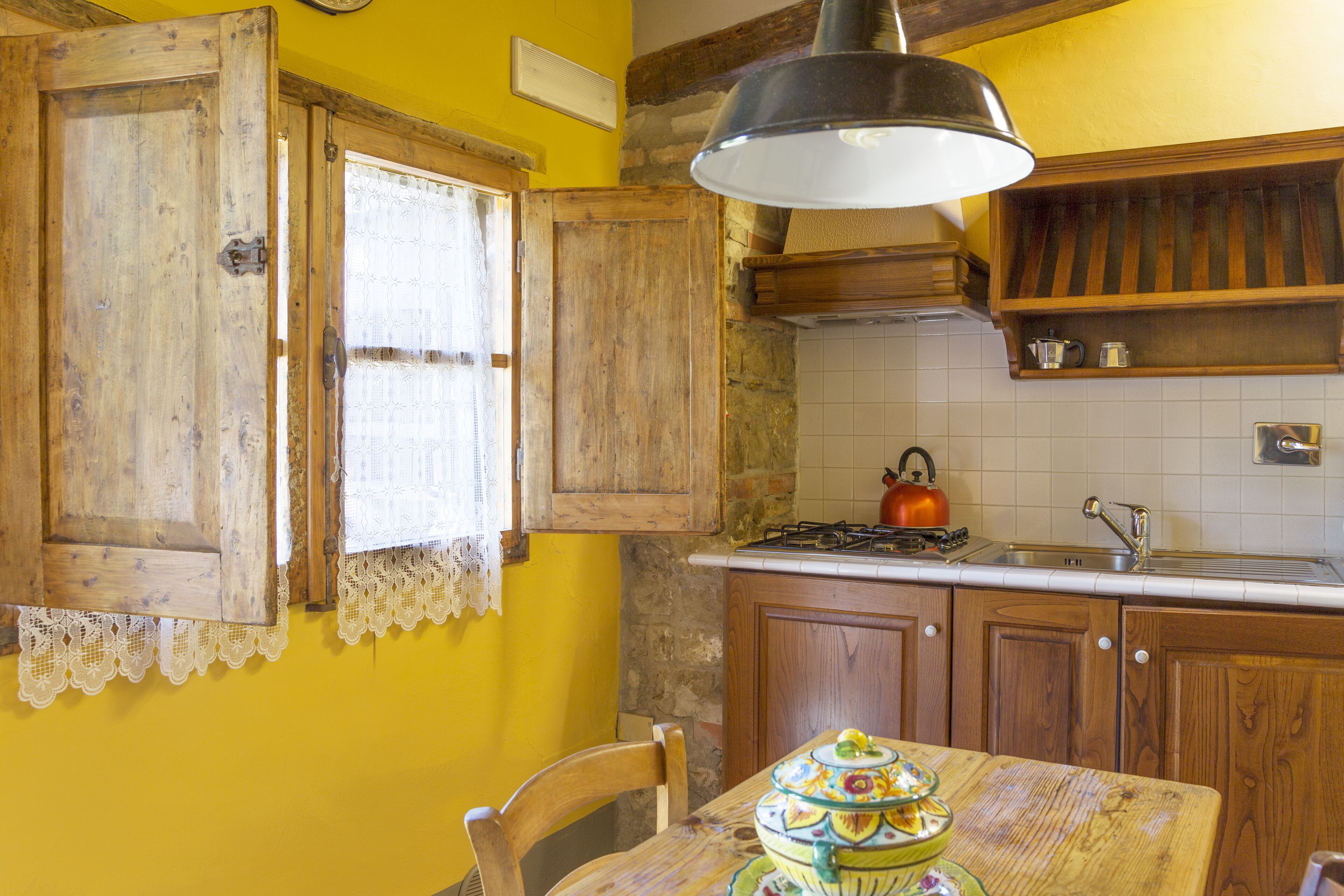 A kitchen with wooden cabinets, a stove, and a table with a decorative centerpiece.