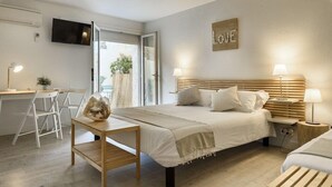 A bedroom with a bed, bedside tables, a desk, and a chair. - Hotel & Studios ASTOR (Antibes)