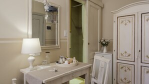 Un baño con tocador, espejo y armario.
