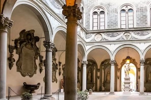 A spacious interior with high ceilings, arched columns, and classical architectural details.