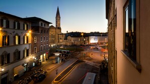 A historic town square with a prominent church tower, cobblestone streets, and a mix of traditional and modern buildings.