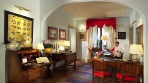 Una habitación tradicional con comedor, un escritorio de madera y una cortina roja.