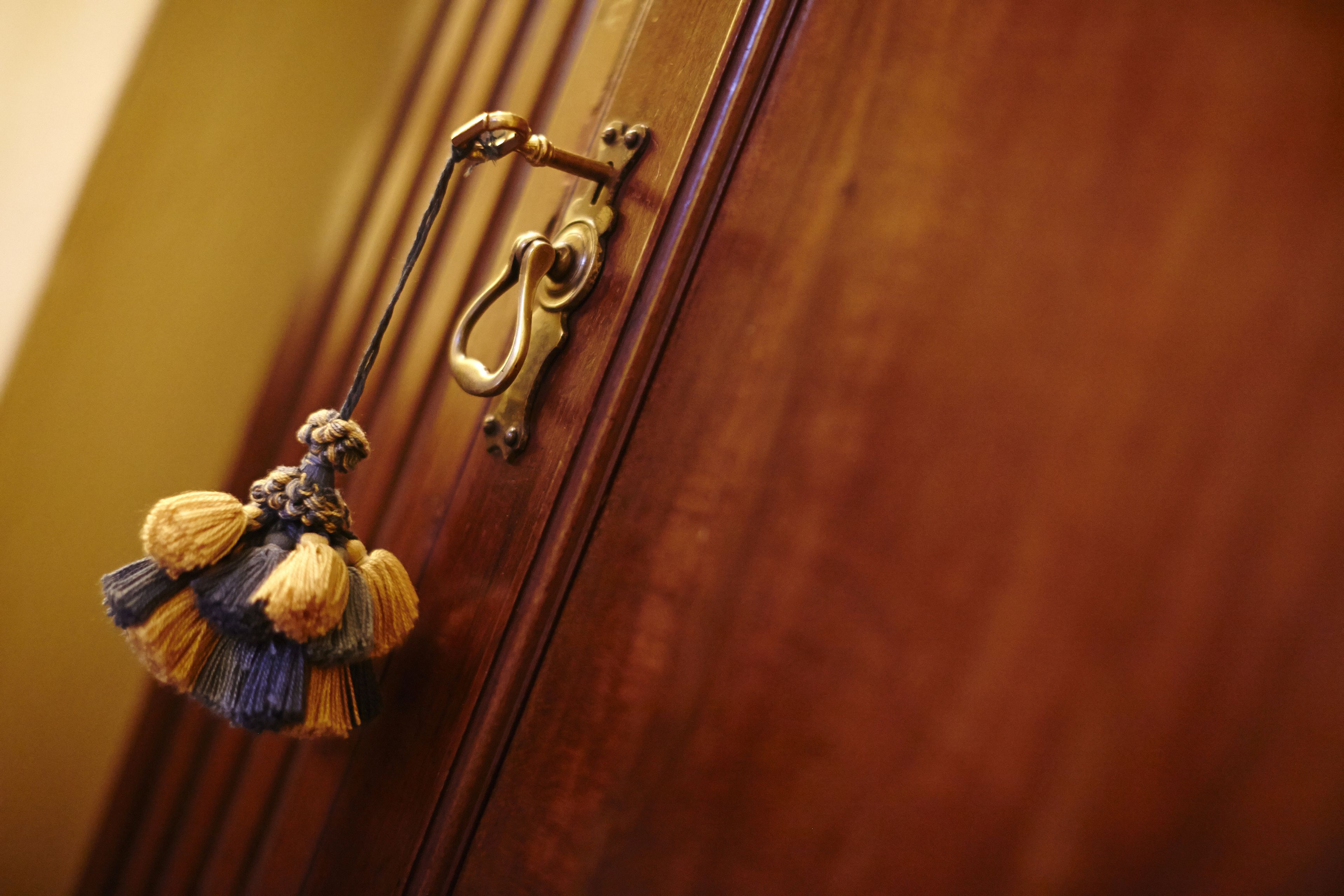 Une porte en bois avec une poignée en laiton et un porte-clés décoratif.