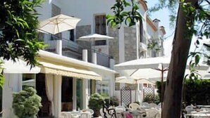 A hotel with outdoor seating, a pool, and a covered area. - Hotel Pierre Loti (Antibes)