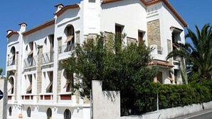 A white building with multiple balconies and a tiled roof. - Hotel Pierre Loti (Antibes)