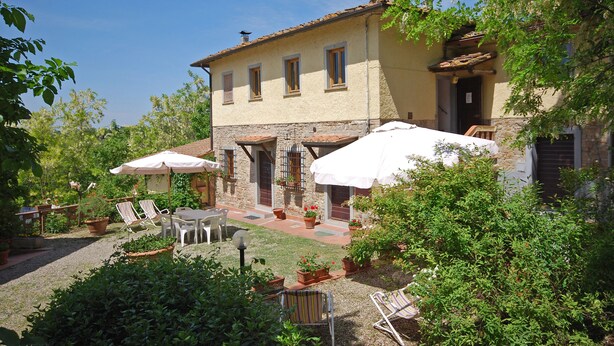 A courtyard with outdoor seating, a stone building, and potted plants. - Podere Poggetto (Barberino Tavarnelle)