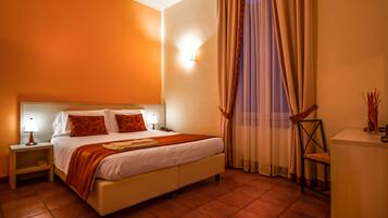 Una habitación de hotel con cama, mesitas de noche, una silla y un escritorio.