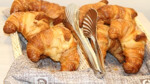 A basket of croissants on a cloth napkin. - Hotel Bella Firenze (Florence)