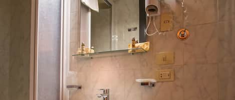 Un baño con lavamanos, espejo e inodoro.