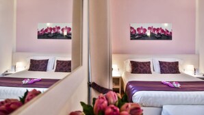 A hotel room with a bed, bedside tables, and a mirror. - Hotel Bella Firenze (Florence)