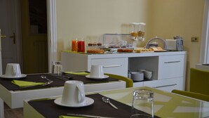 Preparación para el desayuno con barra libre, que incluye platos, vasos y dispensador de zumo.