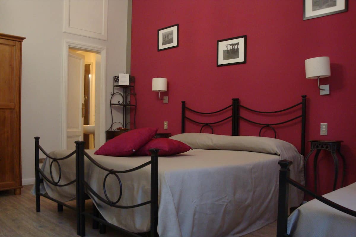 A bedroom with a bed, a nightstand, a lamp, and a wardrobe.