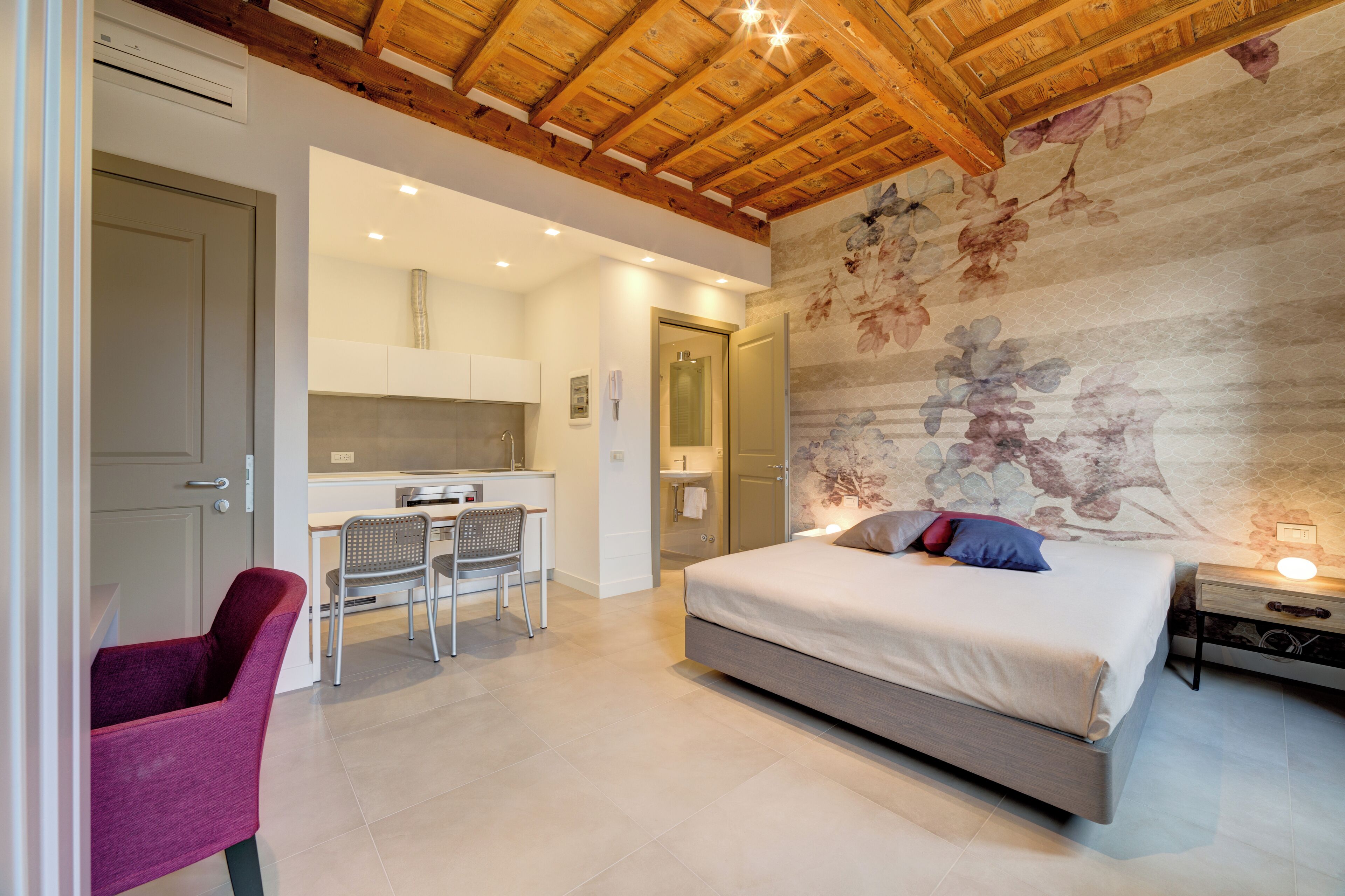 A bedroom with a bed, a desk, and a chair.