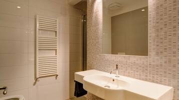Une salle de bain moderne avec un lavabo blanc, un miroir et des toilettes.