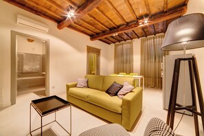 Suite – deluxe, 1 soverom | Oppholdsområde | En 32-tommers Flatskjerm-TV med digitale kanaler samt TV og bøker