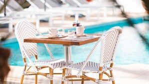 A poolside table with two wicker chairs, a beverage pitcher, and glasses. - Hotel La Villa Juan Beach (Antibes)