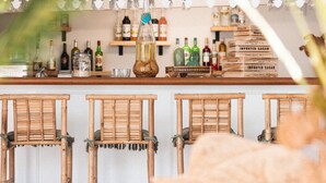 A bar area with wooden chairs, shelves with bottles, and a sign that reads "CARAIE". - Hotel La Villa Juan Beach (Antibes)