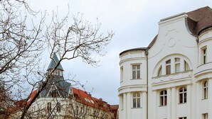 Et gadesyn med en historisk bygning, der har et markant tårn og klassisk arkitektur.