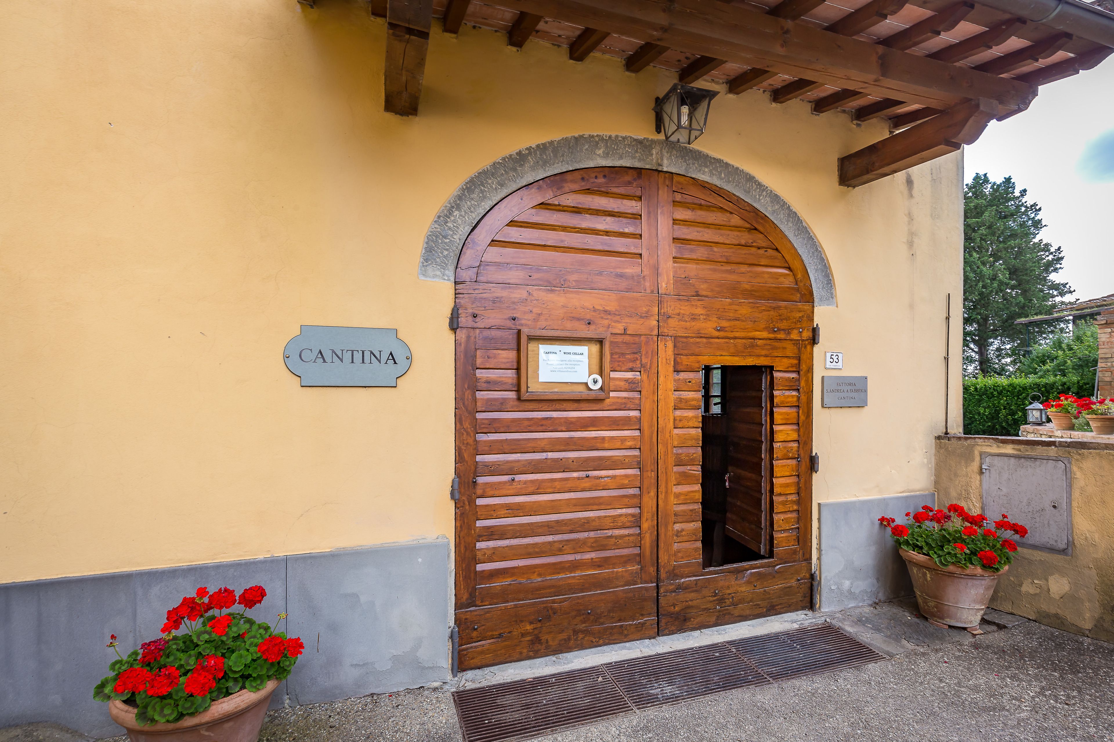 A wooden double door with a sign above it, a small window, and a number '53' on the wall.