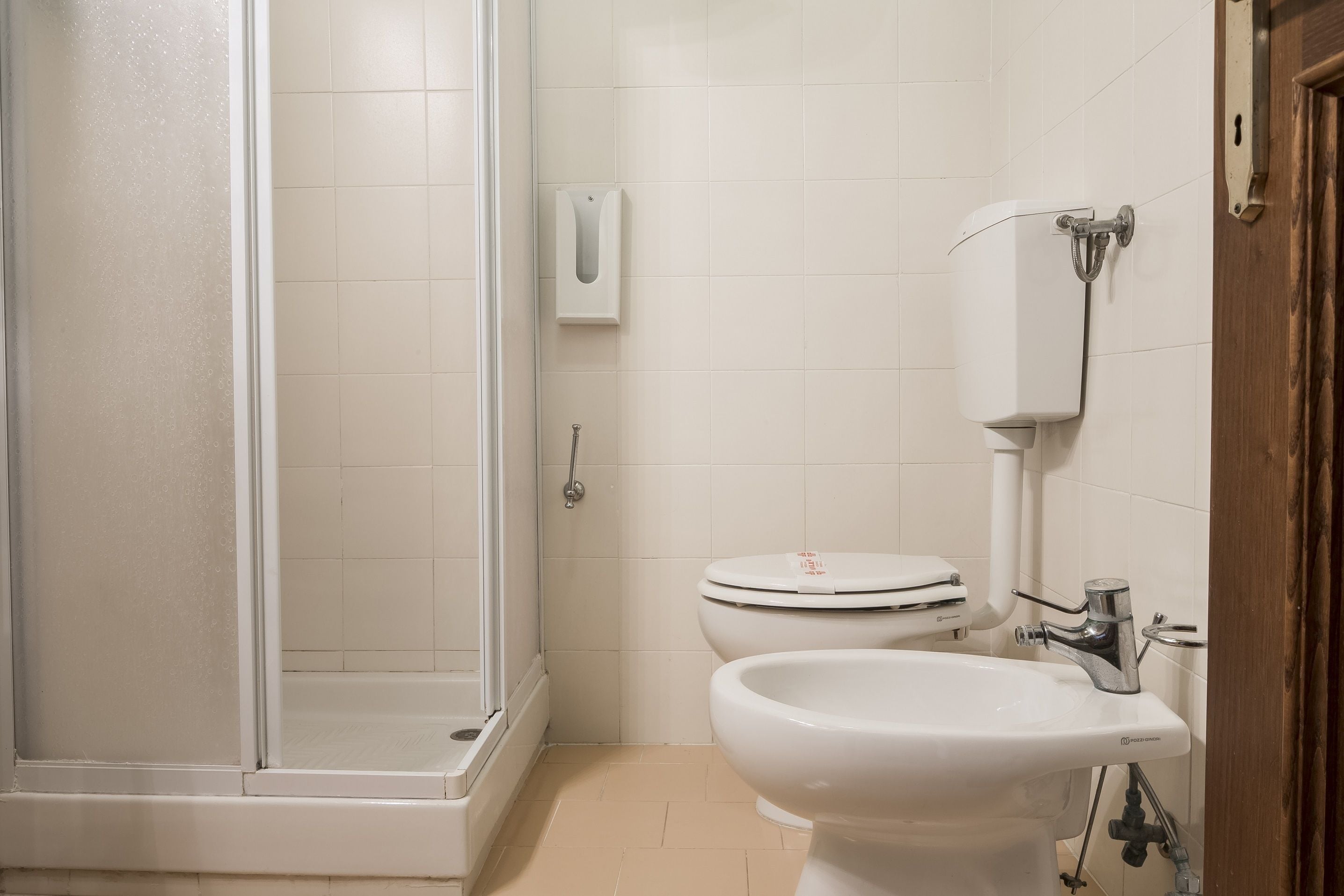 Un baño con ducha de vidrio, inodoro y lavabo.