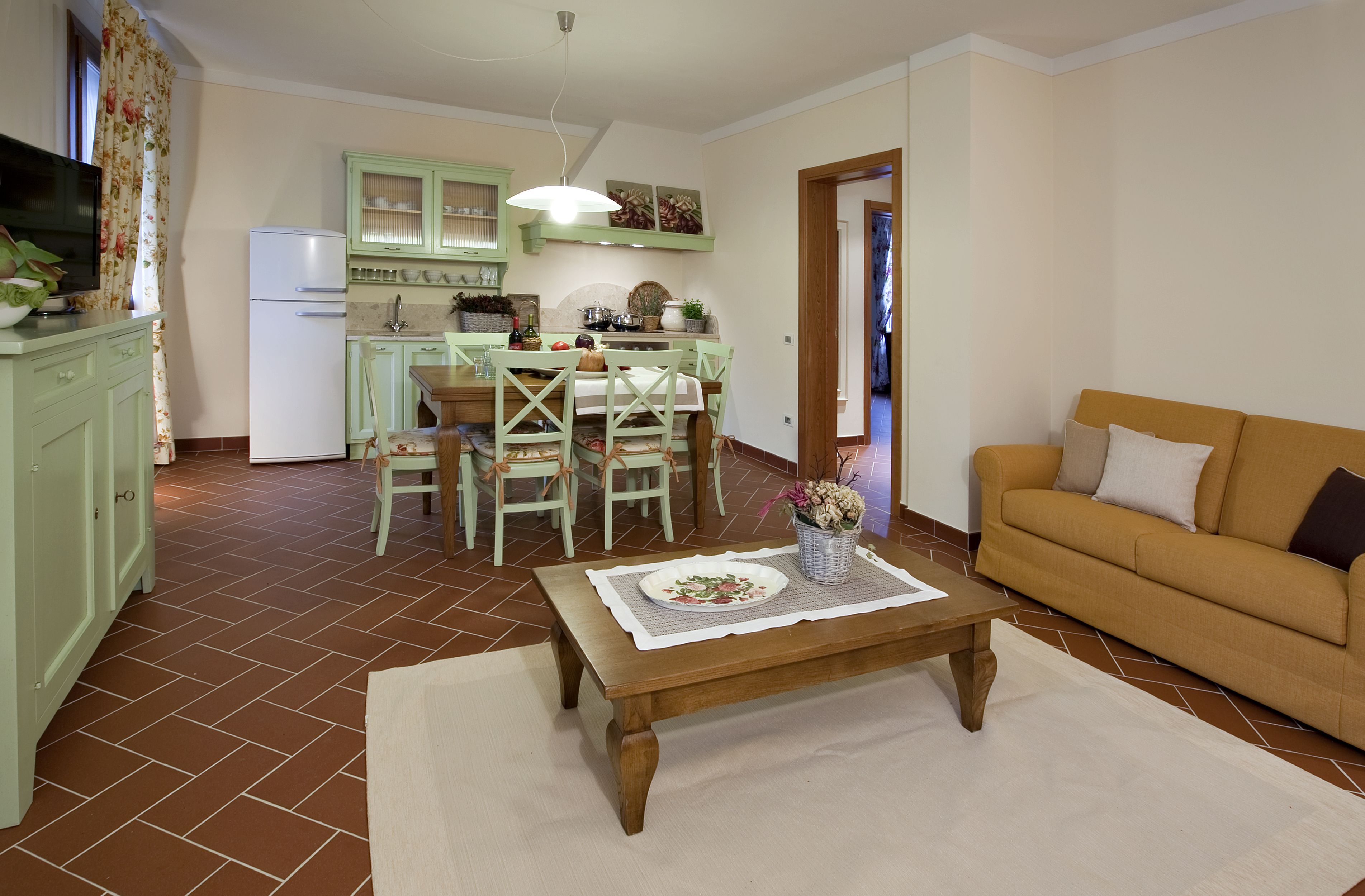Un salon comprenant un canapé, une table basse et un coin repas avec une table et des chaises.