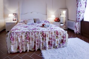 A bedroom with a bed, nightstands, a mirror, and a window with curtains. - Tenuta Quadrifoglio (Gambassi Terme)