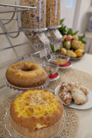 A table with various baked goods including a bundt cake, a pie, and pastries. - Tenuta Quadrifoglio (Gambassi Terme)